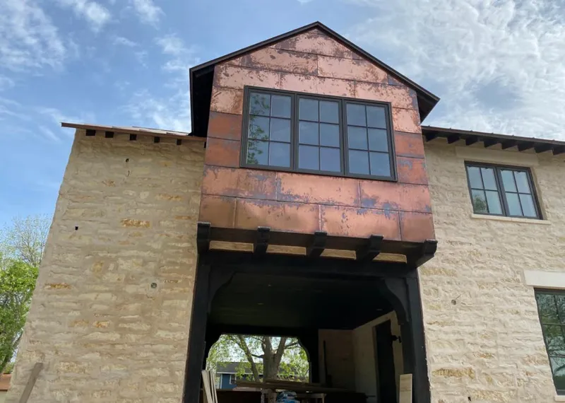 Copper metal panel facade on a stone building for Skylight Installation in Stow