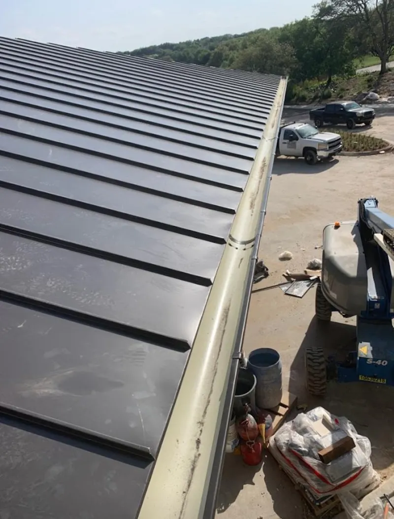 Standing seam panel and gutter detail on a metal roofing jobsite in Stow